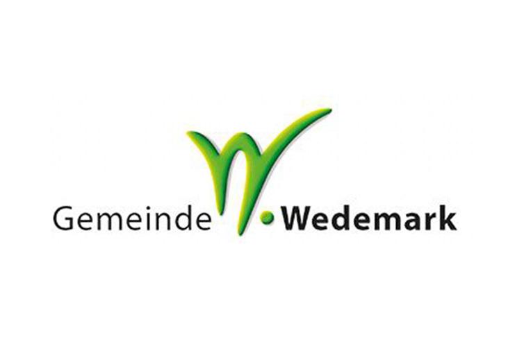 Logo der Gemeinde Wedemark in grüner Schrift mit stilisiertem „W“ und schwarzer Beschriftung.